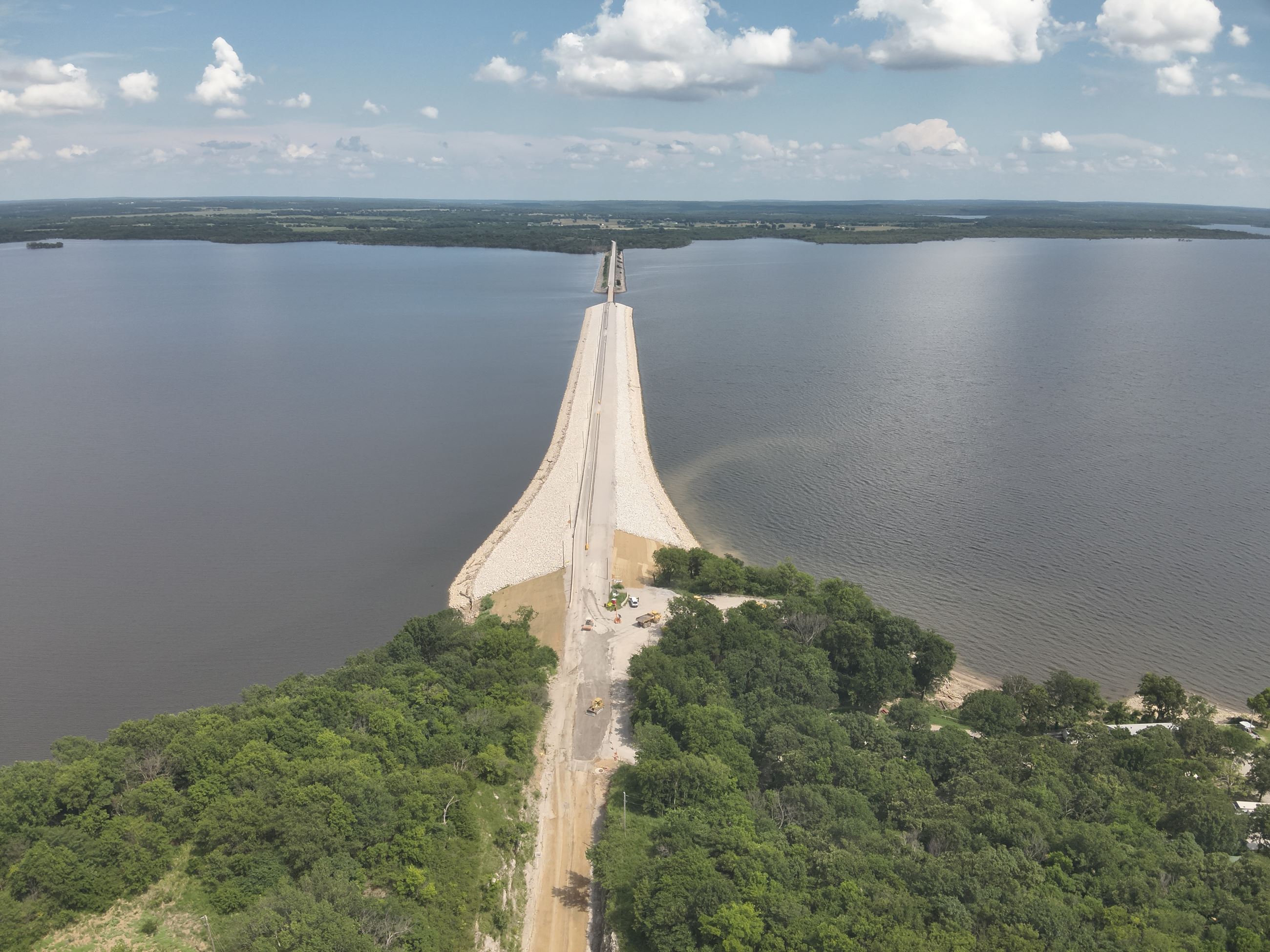 Winganon Causeway shows bluish water, dirt road and green land